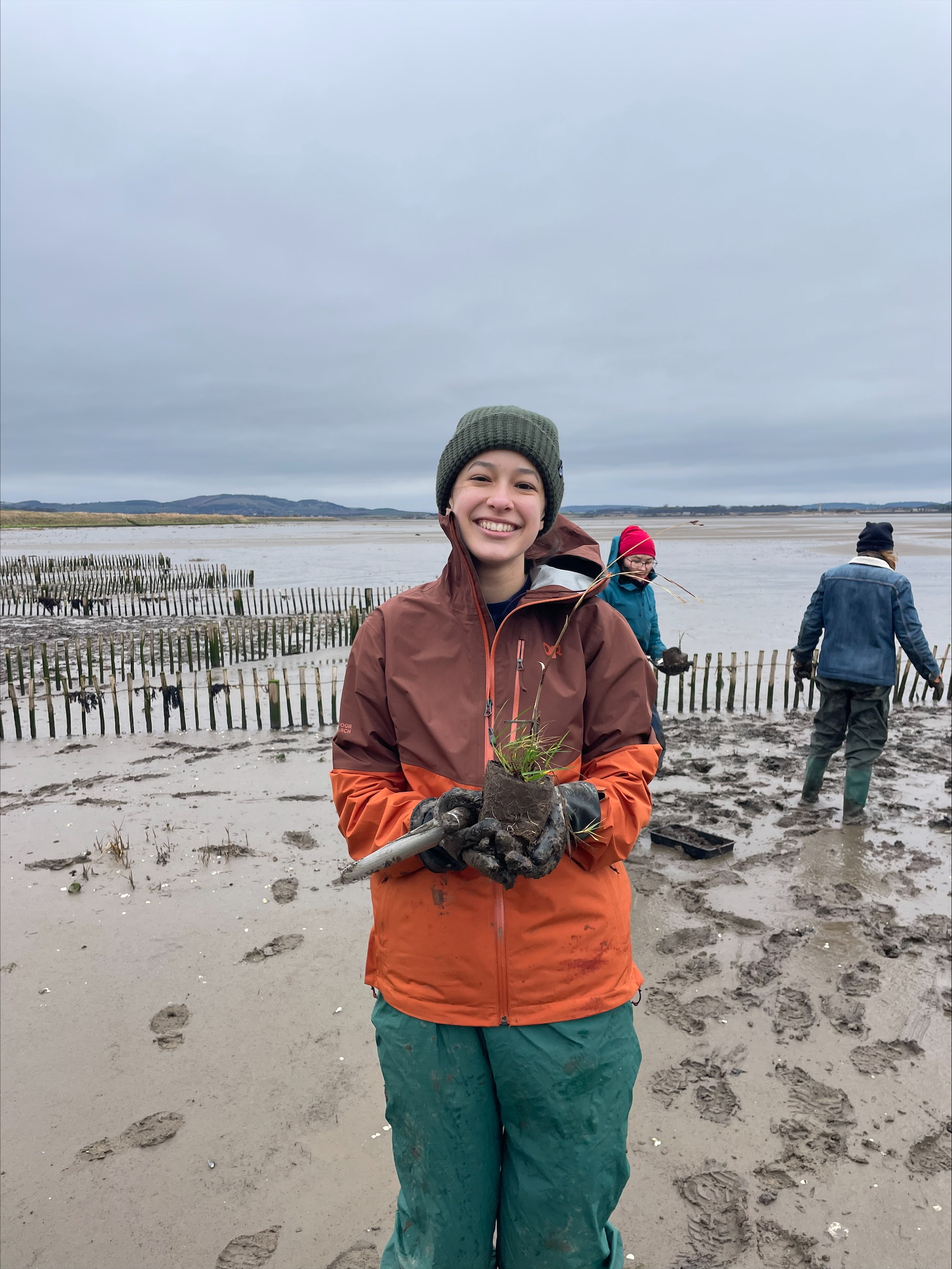 smiling volunteer holding a plant
